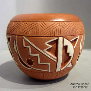 Carved, sgraffito and painted geometric design on a white on red jar