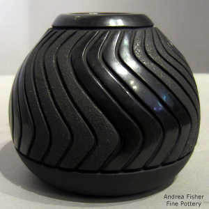 Swirl rib design carved into a black micaceous on black jar