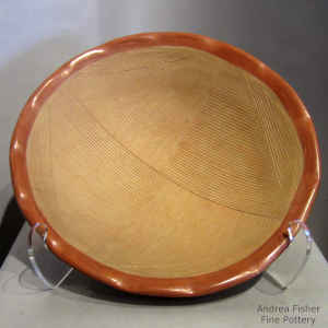 Grooved micaceous geometric design with micaceous slip in a red and tan bowl