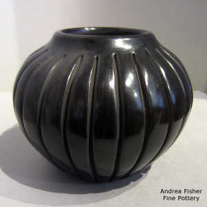 Geometric design carved into a black melon jar