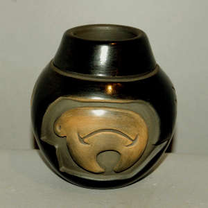 Bear and geometric design carved into a black jar with a sienna spot