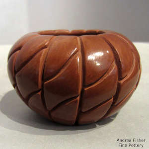 Geometric design carved into a red melon jar