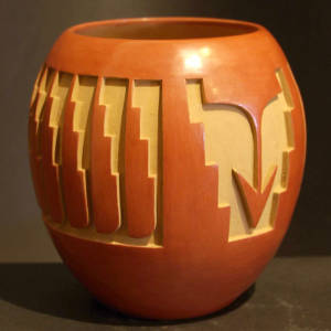 Arrow and feather design carved into a red jar