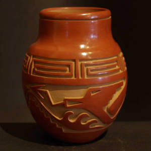 Avanyu and spiral designs carved into a red jar