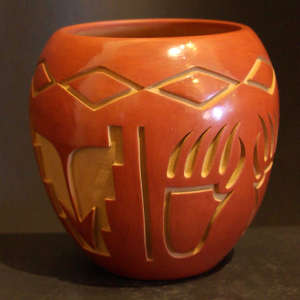 Bear paws, kiva steps and geometric designs carved into a red jar