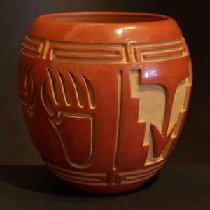 Bear claw, rain, cloud and kiva step design carved into a polished red jar