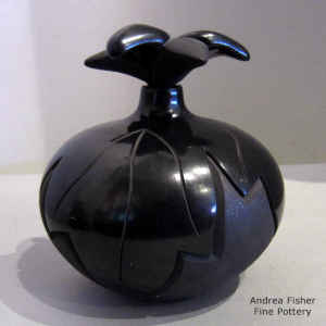 Micaceous black on black jar carved with a leaf design and with a leaf lid