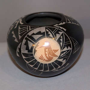 Sgraffito dancer, butterfly, hummingbird and geometric design on a black jar with sienna spots