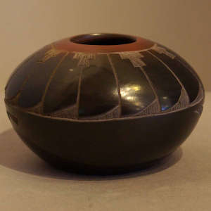 Sgraffito feather design on a black seedpot with sienna rim