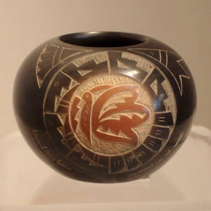 Sgraffito hummingbird, butterfly, feather and geometric design on a black jar with a sienna rim and sienna spots