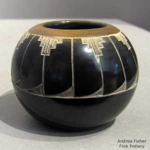 Sgraffito feather design on a black seed pot with a sgraffito feather design