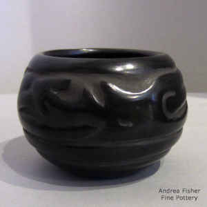 An avanyu design carved into a black jar