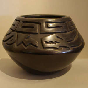Avanyu and geometric designs carved into a black jar