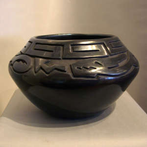 Avanyu and geometric designs carved into a black jar