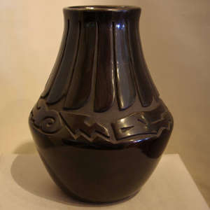 Avanyu and feather design carved into a tall neck black jar