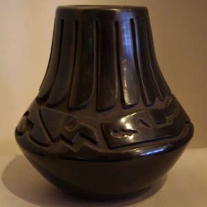 Avanyu and feather design carved into a black jar