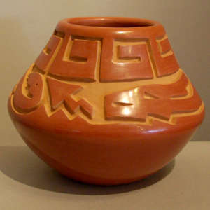 Avanyu and geometric design carved into a red jar