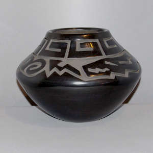 Avanyu and geometric design carved into a black jar