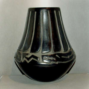 Feather and avanyu design carved into a tall black jar