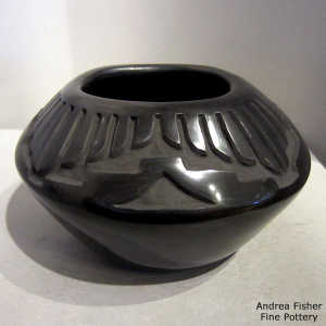 Kiva step and feather design carved into a black jar