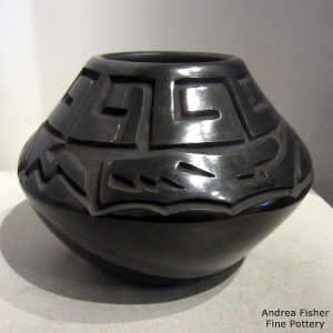 Avanyu and geometric design carved into a black jar
