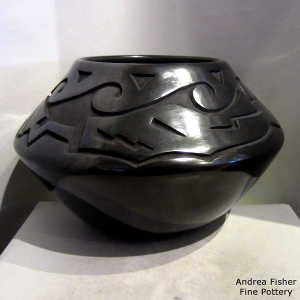 Water and avanyu design carved into a black jar
