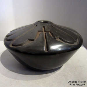 A geometric design carved into a low-shouldered black jar