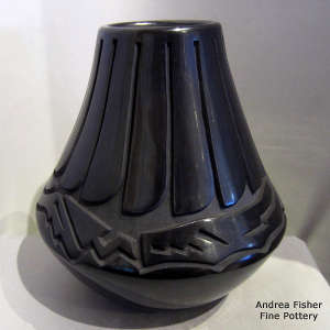 Feather and avanyu design carved into a tall black jar
