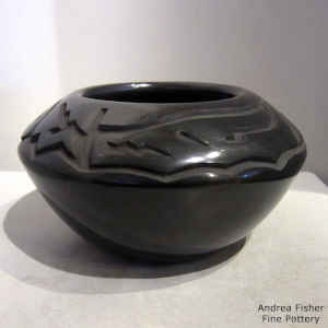 Black jar carved with an avanyu design