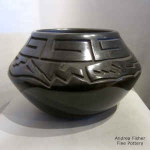 An avanyu design carved into a black jar