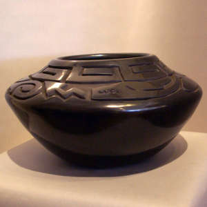 Avanyu and geometric design carved into a black jar