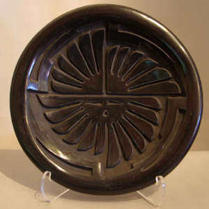 Sun face carved into a black plate