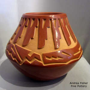 Avanyu, feather and geometric design carved into a red jar