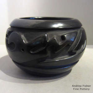 An avanyu design carved into a polished black bowl