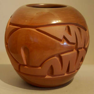 Bear and stylized heart line design carved into a brown jar