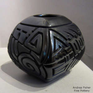Geometric design carved into a square black on black jar