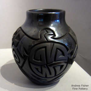 Stylized eagle and geometric design carved into a black on black jar