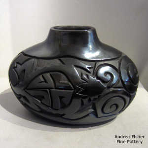 Spiral, rabbit, horned toad and geometric design carved into a black on black oval jar