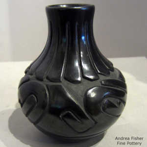 Feather and avanyu design carved into a black jar