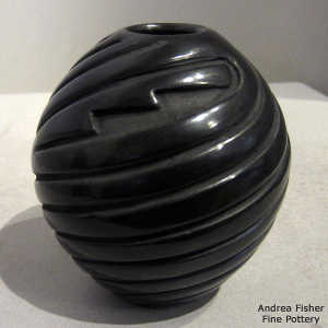 Swirl and geometric design carved into a black jar