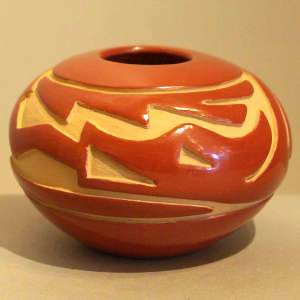 Avanyu design carved into a red jar