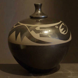 An avanyu design on a lidded black on black jar