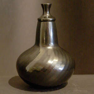 Swirl faceted base on a black lidded vase