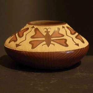 Sgraffito butterfly and arrow design on a polished brown jar