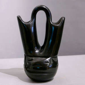 An avanyu design carved into a black wedding vase