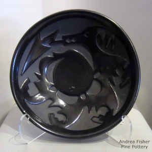 A black plate carved with an avanyu design