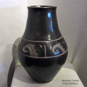 A band of geometric design is carved around the shoulder of a black urn