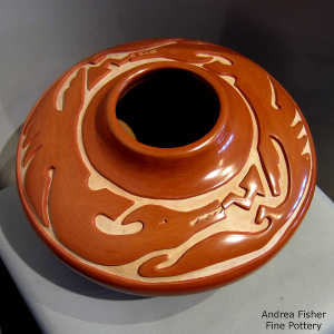 Double avanyu design carved into a red jar