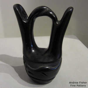 An avanyu design carved into a black wedding vase