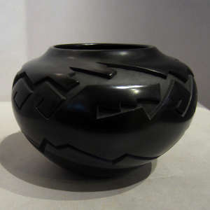 Geometric design carved into a polished black jar